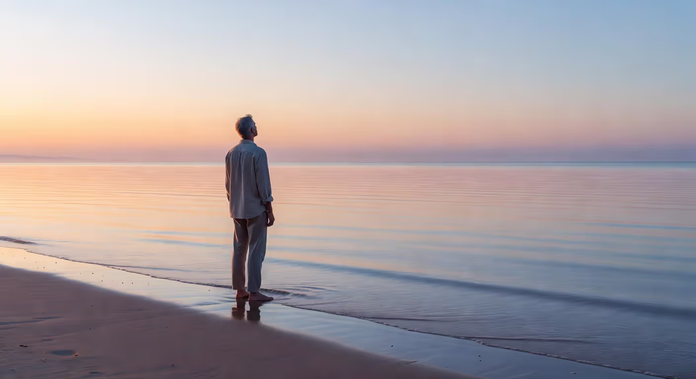 Person standing at ocean's edge contemplating new beginning after divorce